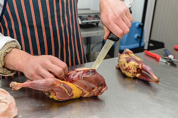 A game meat butcher preparing meat