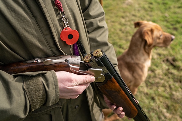 A shooter holding a broken shotgun