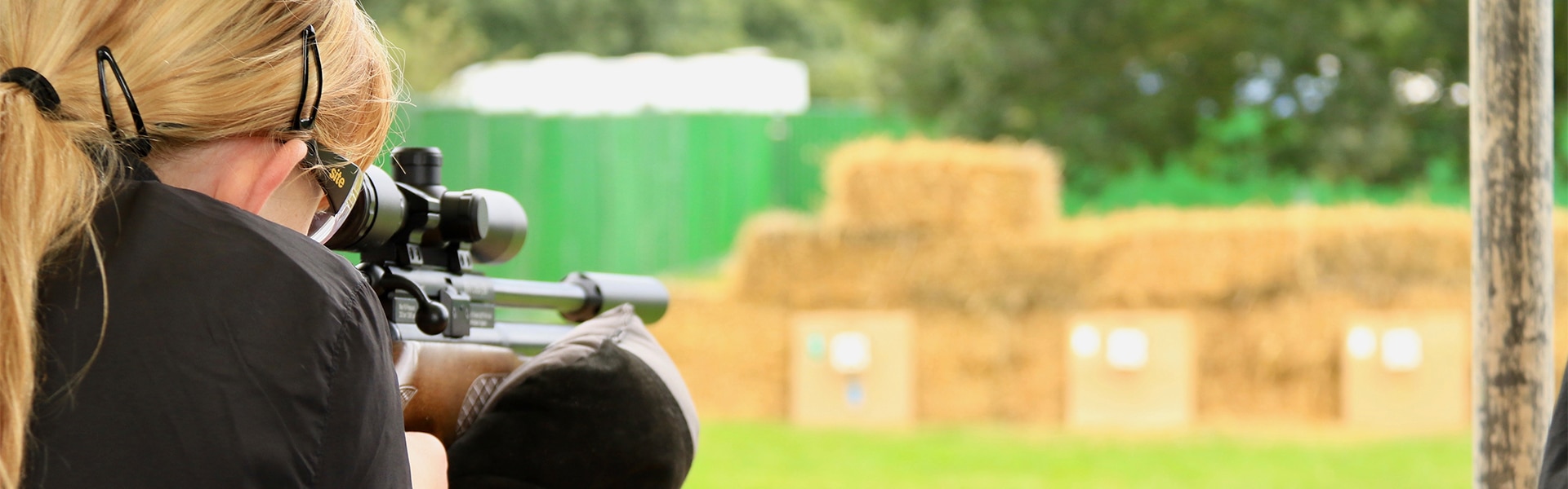 Air rifle shooter aiming down her scope