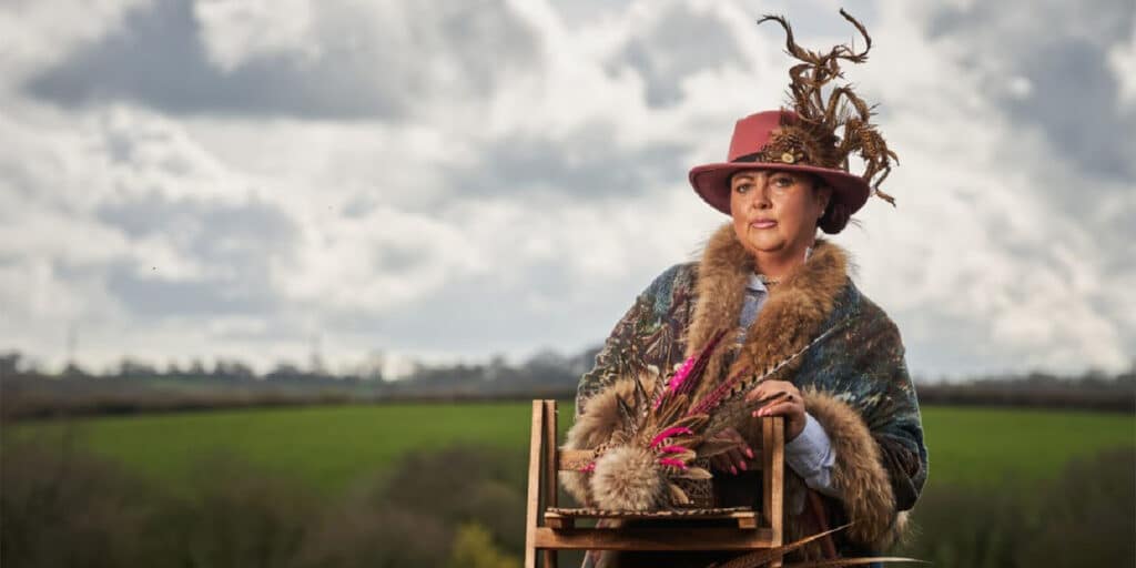 A lady standing with her feathered hats