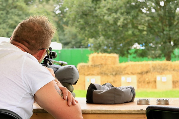 An airgun shooter aiming down a range