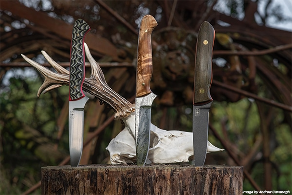 Three knives impaled into a log standing up straight