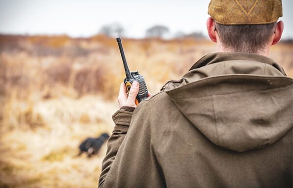 A game shooter holding a hand radio