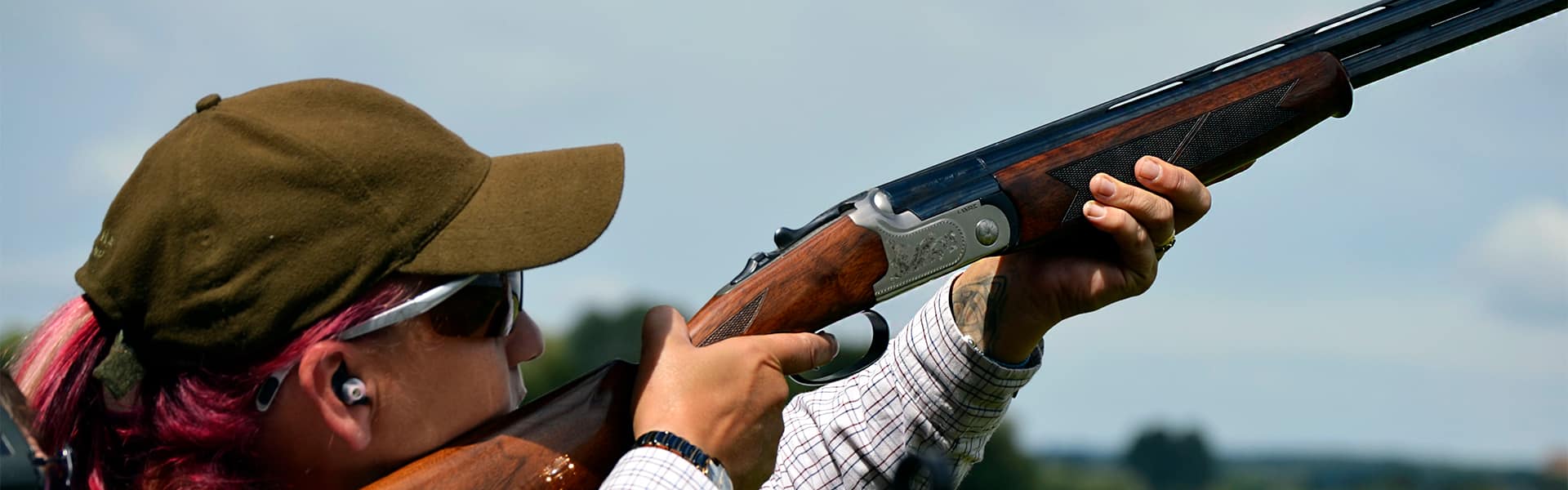 A woman shooter aiming a shotgun