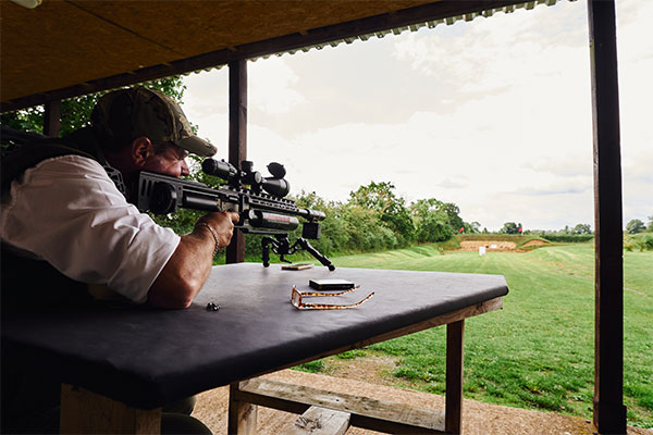 Air rifle shooter aiming down a range