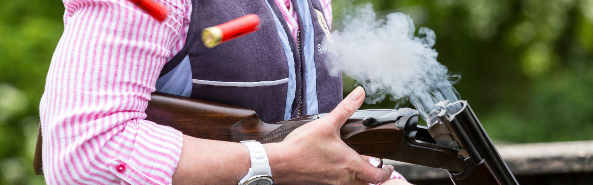 Game shooter holding a shotgun ejecting cartridges
