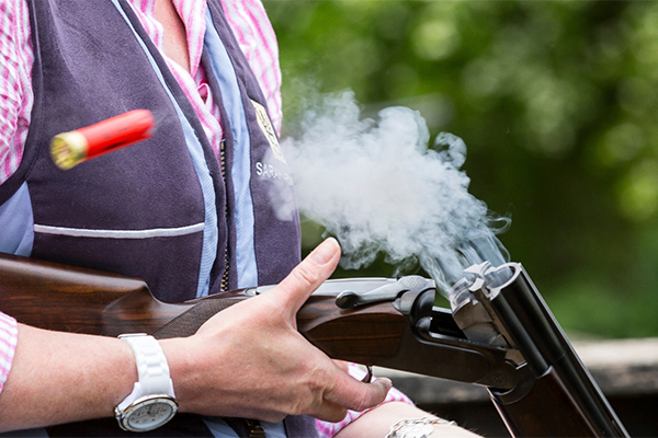 Game shooter holding a shotgun ejecting cartridges