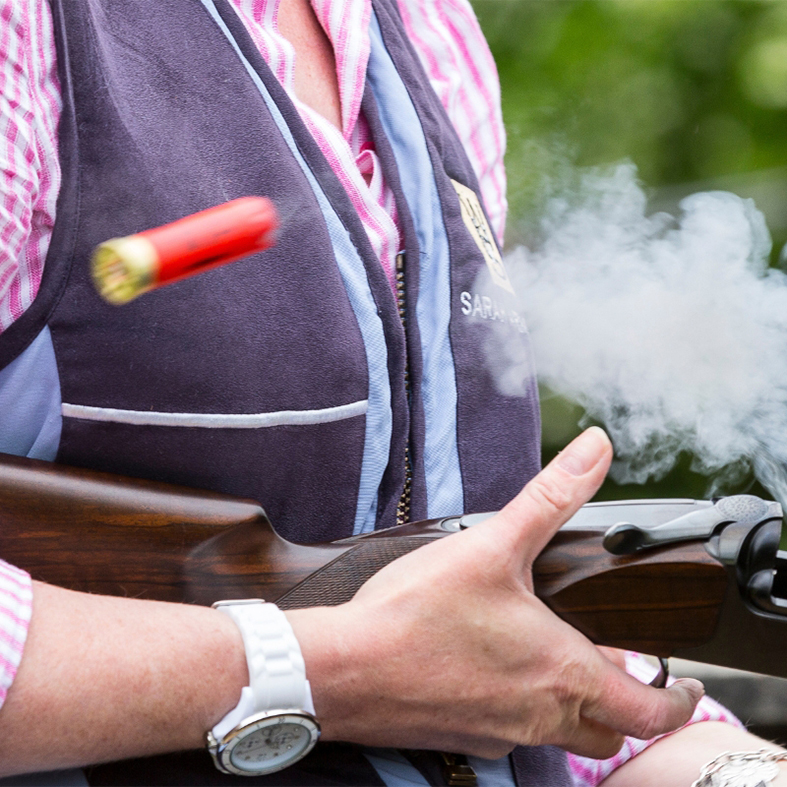 Game shooter holding a shotgun ejecting cartridges