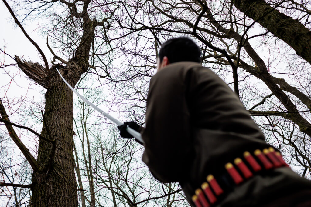 A pest controller disturbing squirrels with a long pole