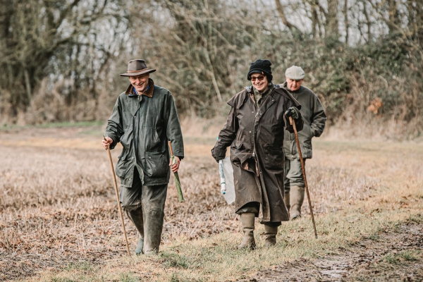 two beaters walking across a stubble field