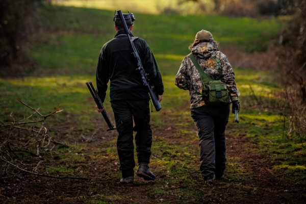 two people walking with rifle